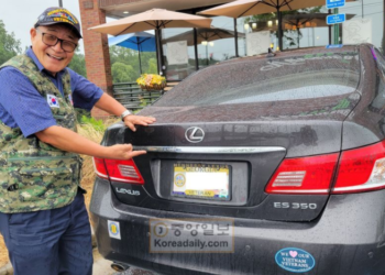 조영준 회장이 베트남전 참전 국가 유공자회 조끼를 입고 조지아주에서 발급해준 참전용사 차량 번호판을 가리키고 있다.