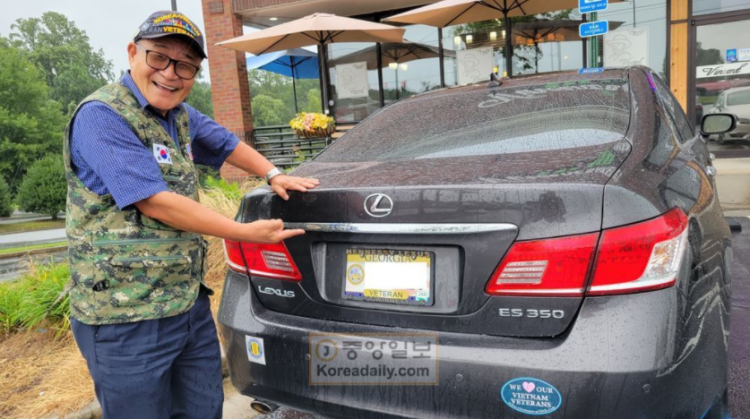 조영준 회장이 베트남전 참전 국가 유공자회 조끼를 입고 조지아주에서 발급해준 참전용사 차량 번호판을 가리키고 있다.