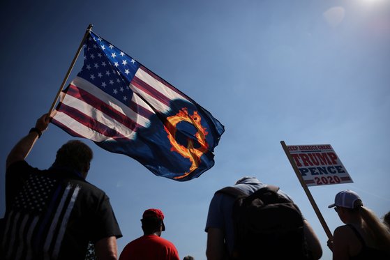 오리건주에서 한 트럼프 지지자가 성조기에 '큐어넌(QAnon)'을 뜻하는 'Q'를 새긴 깃발을 흔들고 있다. [로이터=연합뉴스]