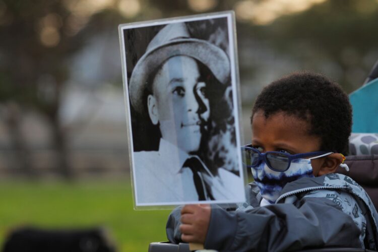 2021년 5월에 열린 조지 플로이드 1주년 추모식에서 4살 소년이 14세에 린치로 사망한 에멧 틸의 사진을 들고 있다. May 25, 2021. REUTERS/Brian Snyder