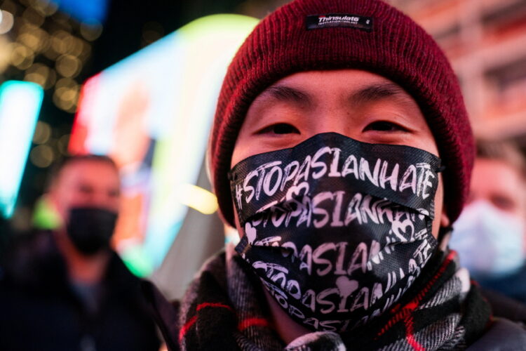 뉴욕 타임스퀘어에서 '아시아인 혐오를 멈춰라'라는 문구가 적힌 마스크를 쓴 한 남성이 지하철 앞에서 노숙자에게 밀쳐 숨진 미셸 고를 위한 촛불집회에 참석하고 있다. January 18, 2022. REUTERS/Jeenah Moon