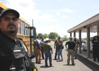 5월 24일 텍사스주 유밸디에 있는 롭 초등학교 총격 현장을 경찰이 지키고 있는 가운데 한 어린이가 스쿨버스 에 올라타고 있다. REUTERS/Marco Bello