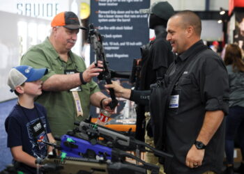 2022년 5월27일 텍사스 휴스턴에서 열린 전미총기협회 컨벤션에서 아버지가 아들에게 권총 개조 키트를 보여주고 있다.  REUTERS/Shannon Stapleton