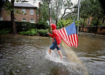 9월 30일 사우스 캐롤라이나 찰스턴에서 허리케인 이안으로 홍수에 떠내려간  미국 국기를 되찾아 걷고 있다. 로이터 사진.