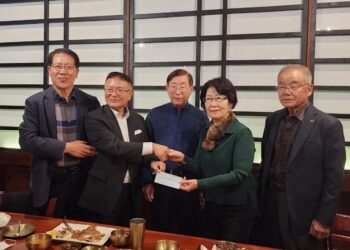 주중관 박사 내외가 이홍기 한인회장에게 기부금을 전달하고 있다. 한인회 제공 사진.