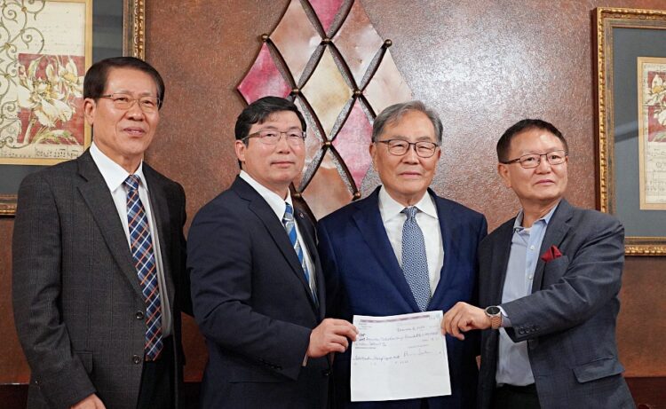 박선근 회장이 15일 기자회견에서 100만달러 체크를 들고 한인회 관계자들과 기념사진을 찍었다. 윤지아 기자.