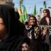 2022년 9월 26일 시리아 북동부 쿠르드족 통제 도시 카미슐리에서 22세 쿠르드족 여성 마흐사 아미니의 죽음에 항의하는 여성들이 깃발과 사진을 들고 시위를 벌이고 있다. 로이터 사진.