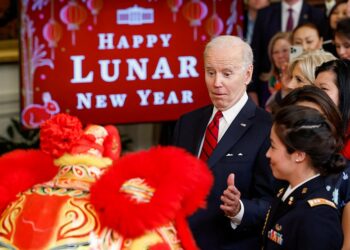 조 바이든 대통령이 26일 백악관에서 열린 음력 설 축하 행사에서 사자 탈춤을 보며 놀라고 있다. 로이터.