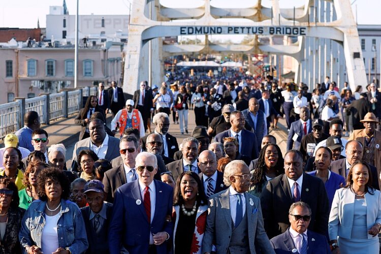 조 바이든 대통령, 제시 잭슨 목사, 알 샤프턴 목사, 테리 세웰  연방 하원의원(D-AL)이 '피의 일요일' 58주년을 기념해 에드먼드 페터스 다리를 건너는 기념 행진에 참여하고 있다. 로이터