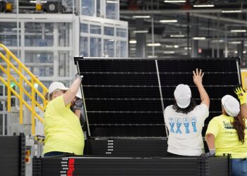 Employees work on solar panels at the QCells solar energy manufacturing factory in Dalton, Georgia, U.S., March 2, 2023. REUTERS/Megan Varner