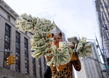 지난달 31일 뉴욕 맨해튼 형사법원 앞에서 트럼프 반대 시위자가 입막음용 돈을 상징하는 달러 피켓으로 기소 축하 시위를 벌이고 있다. 로이터