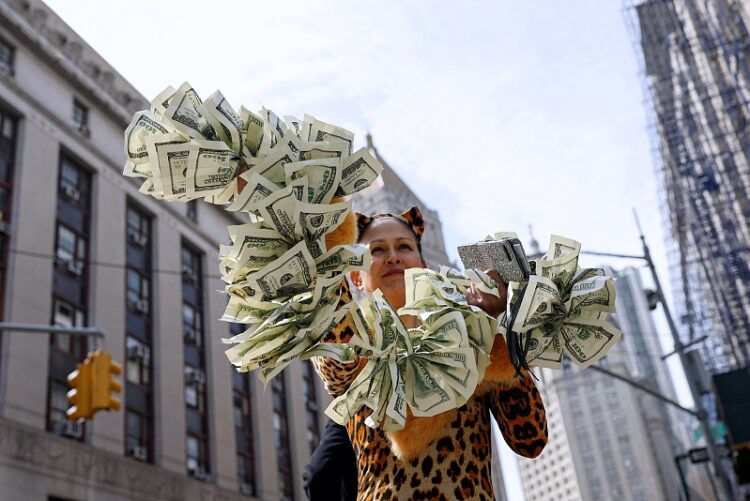 지난달 31일 뉴욕 맨해튼 형사법원 앞에서 트럼프 반대 시위자가 입막음용 돈을 상징하는 달러 피켓으로 기소 축하 시위를 벌이고 있다. 로이터