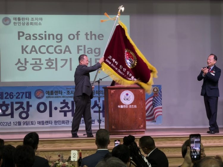 한오동 신임 회장이 썬 박 전임 회장으로부터 상공회기를 전달받았다. 윤지아 기자.