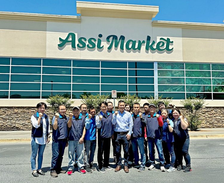 로빈 리(가운데) 대표와 스와니 아씨마켓 직원들이 새로 바뀐 간판 앞에서 화이팅을 외쳤다. 윤지아 기자