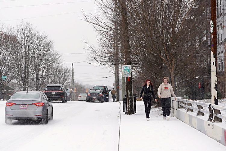 2025년 1월 21일 미국 조지아주 애틀랜타에 눈이 내리는 가운데 한 커플이 거리를 걷고 있다.