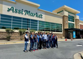 2024년 아씨마켓 관계자들이 새로 바뀐 간판 앞에서 파이팅을 외치고 있다. 윤지아 기자.