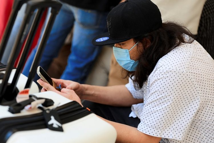 미국에서 자진 추방 형식으로 송환된 불법체류자가 온두라스 산페드로술라 지역에서 휴대전화를 들여다보고 있다. [로이터]