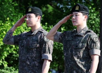육군 현역 복무를 마치고 만기 전역한 그룹 방탄소년단(BTS)의 지민(오른쪽)과 정국이 11일 경기도 연천군 연천공설운동장에서 거수경례를 하고 있다. [로이터]