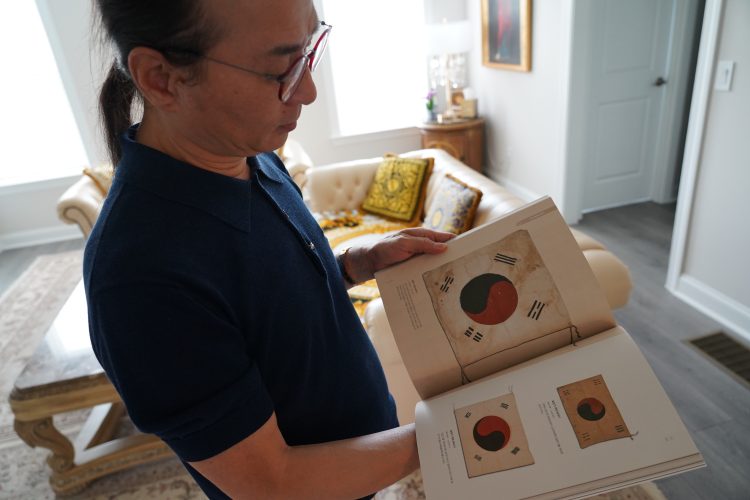 태극기 소장 유물 도록을 보여주는 이병근씨. 장채원 기자