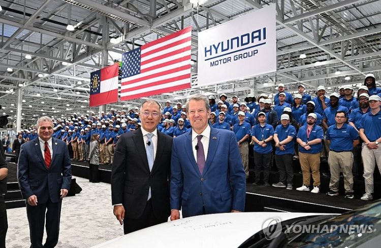 정의선 현대차그룹 회장이 지난 3월 조지아  메타플랜트 아메리카'(HMGMA)의 준공식에서 아이오닉 5 차량에 기념 서명을 마친 후 브라이언 캠프 조지아 주지사와 기념 촬영하고 있다. [연합뉴스]