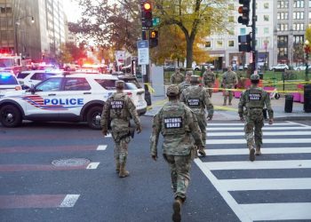 26일 워싱턴 백악관 앞 총격사건 현장 인근 거리를 주방위군 병사들이 걷고 있다. [로이터]