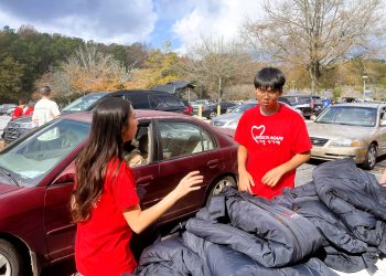 지난 22일 사우스디캡 몰에서 미션아가페 봉사자들이 사랑의 점퍼를 배포하고 있다.