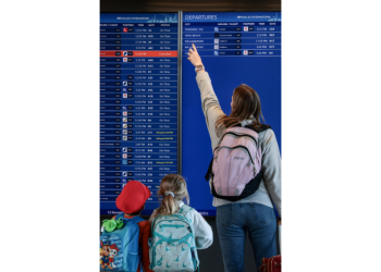 13일 버지니아주 덜레스 공항에서 여행객들이 운항 스케줄을 확인하고 있다. [로이터]