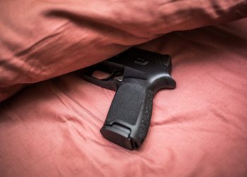 침대 위에 올려둔 총. [출처 셔터스톡]