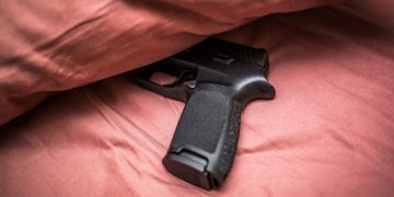 침대 위에 올려둔 총. [출처 셔터스톡]