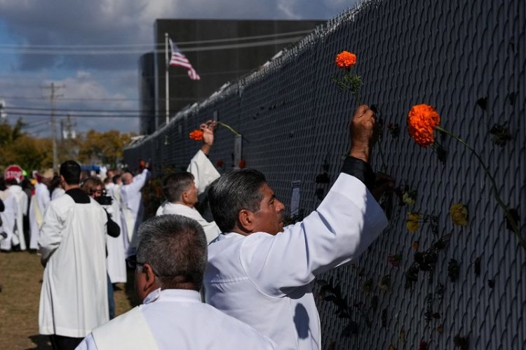 가톨릭 사제들이 시카고 브로드뷰 ICE(이민세관단속국) 구치소 주변에 매리골드 꽃을 꽂고 있다. [로이터]