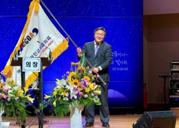 손정훈 신임 회장이 교협기를 받아 흔들고 있다.  윤지아 기자.