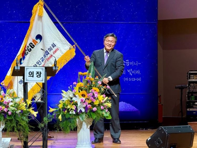 손정훈 신임 회장이 교협기를 받아 흔들고 있다. 윤지아 기자.