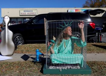 지난 17일 연방 당국의 무차별 이민단속에 항의, 한 시위자가 자유의 여신상 분장을 하고 철장 속 퍼포먼스를 보여주고 있다. [로이터]