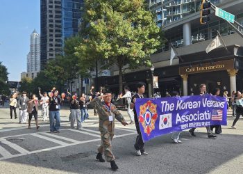 장경섭 회장(맨 앞줄 왼쪽)과 한인 봉사자들이 미드타운 카페 인터메조 앞을 지나며 8일 오전 퍼레이드에 참가하고 있다.