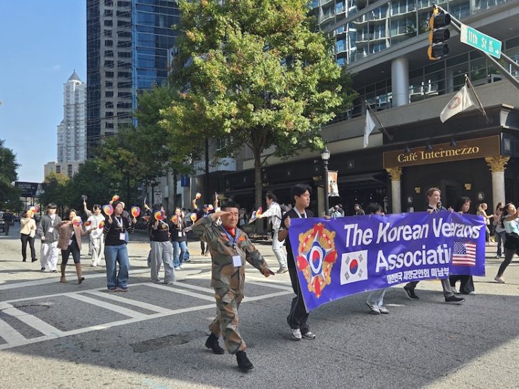 장경섭 회장(맨 앞줄 왼쪽)과 한인 봉사자들이 미드타운 카페 인터메조 앞을 지나며 8일 오전 퍼레이드에 참가하고 있다.