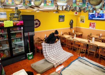 2일 뉴올리언스 가족 운영 식당 내부에 간이 침대 만드는 여성. [로이터]