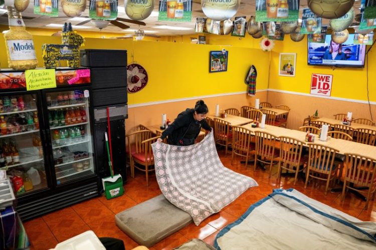 2일 뉴올리언스 가족 운영 식당 내부에 간이 침대 만드는 여성. [로이터]