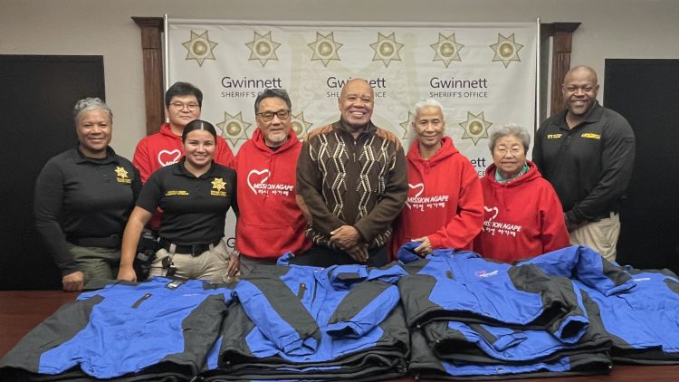 미션아가페 자원봉사자들과 키보 테일러 귀넷 셰리프 등 셰리프국 관계자들이 9일 사랑의 점퍼 앞에서 기념사진을 찍었다.