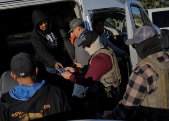 2025년 12월 19일, 캘리포니아주 메카에서 이민세관단속국(ICE) 요원들이 식료품점 주차장에서 농장 노동자들의 신분증을 확인하고 있다. [로이터]