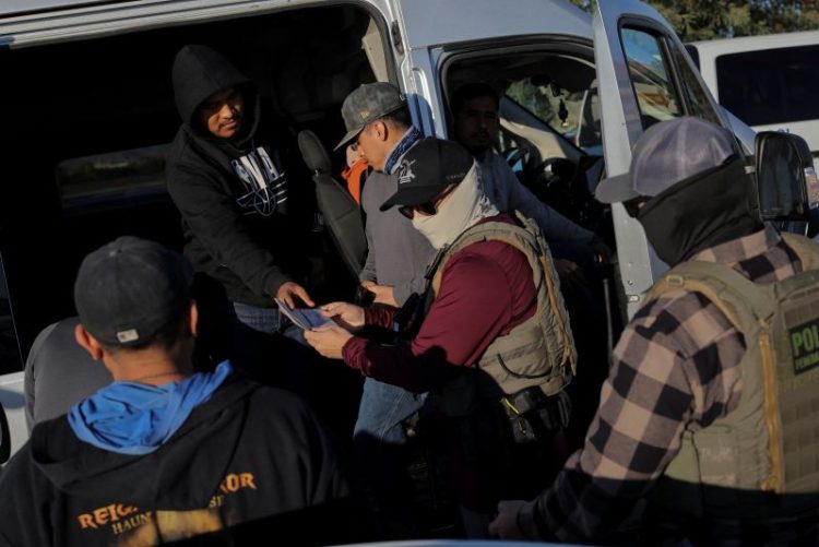 2025년 12월 19일, 캘리포니아주 메카에서 이민세관단속국(ICE) 요원들이 식료품점 주차장에서 농장 노동자들의 신분증을 확인하고 있다. [로이터]