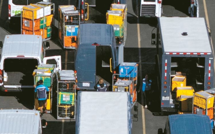 가주 발렌시아에 위치한 아마존 물류센터에서 직원들이 배송트럭에 온라인 주문 상품들을 싣고 있다. [로이터]