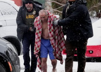 지난 18일 이민단속 요원들이 미네소타주 세인트 폴의 한 주택에 진입해 영하의 날씨에도 불구, 겉옷을 입지 않은 한 남성을 연행하고 있다. [로이터]