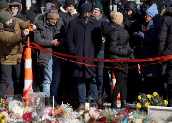 라파엘 워녹 연방 상원의원(조지아주)이 27일 미니애폴리스를 방문, 이민단속 요원 총격으로 숨진 알렉스 프레티를 기리는 추모소 앞에서 주민들과 함께 고인을 추모하고 있다. [로이터]