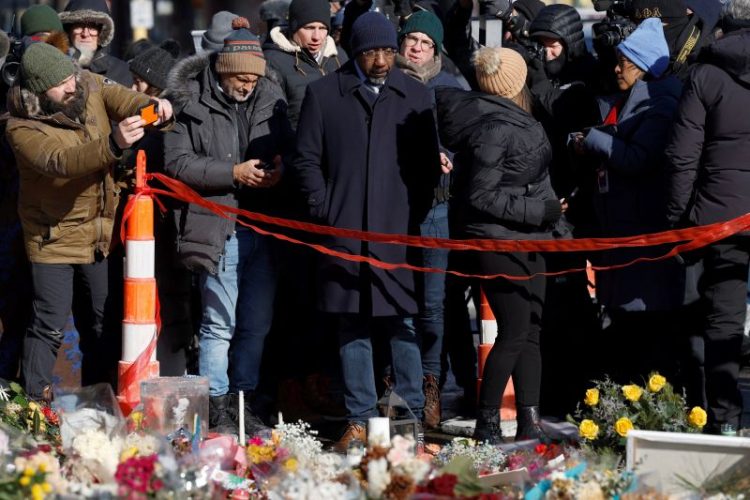 라파엘 워녹 연방 상원의원(조지아주)이 27일 미니애폴리스를 방문, 이민단속 요원 총격으로 숨진 알렉스 프레티를 기리는 추모소 앞에서 주민들과 함께 고인을 추모하고 있다. [로이터]