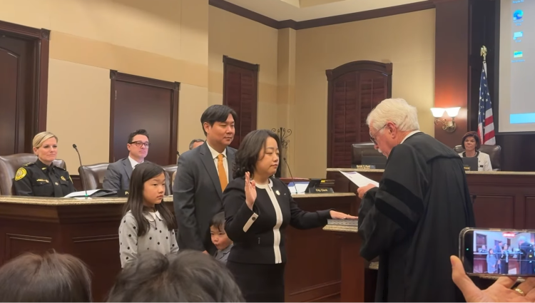 사라 박 신임 시의원이 12일 둘루스 시청에서 가족들이 지켜보는 가운데 취임 선서를 하고 있다.