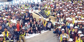 기가팩토리 직원들이 첫 출고차와 함께 자축하고 있다. [테슬라 제공]