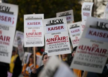 지난 2월 9일 캘리포니아주 로스앤젤레스의 카이저 퍼머넌트 병원 앞에서 카이저 퍼머넌트 약국 및 검사실 직원들이 "부당 노동 행위 파업"에 항의하는 피켓 시위를 벌이며 팻말을 들고 있다. [로이터]