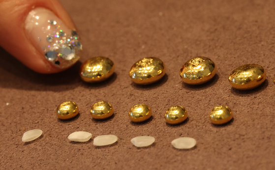 서울 종로구 귀금속 거리 한 금은방에서 관계자가 한 돈(3.75g), 1g 콩알금 크기를 쌀알과 비교해 설명하고 있다. 연합뉴스.