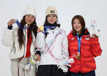 최가온(가운데)이 시상대에서 금메달을 보여주고 있다. 왼쪽은 은메달 클로이 김, 오른쪽은 동메달 오노 미쓰키. [로이터]