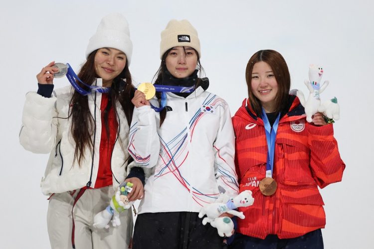 최가온(가운데)이 시상대에서 금메달을 보여주고 있다. 왼쪽은 은메달 클로이 김, 오른쪽은 동메달 오노 미쓰키. [로이터]